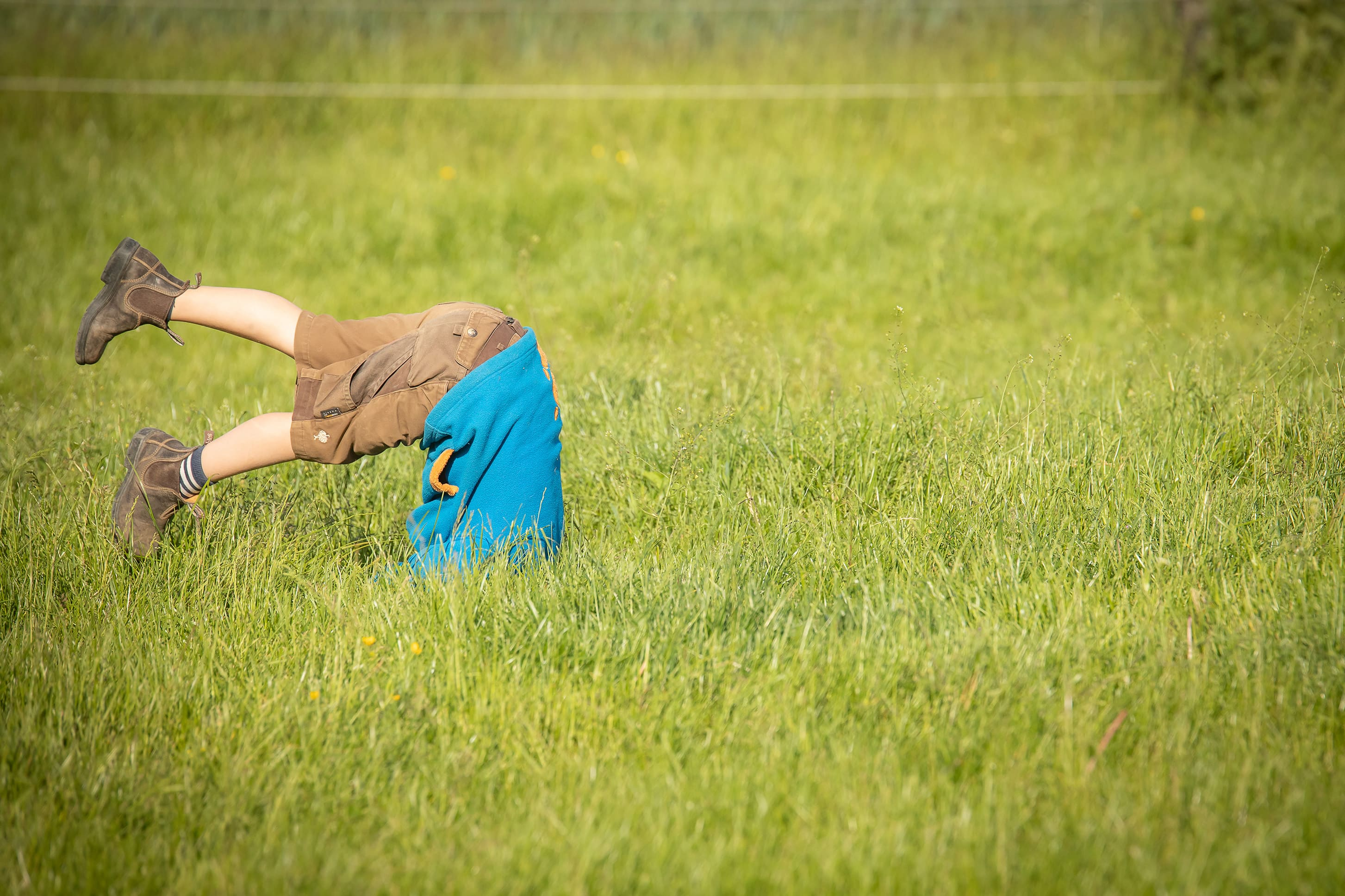 Kind über Kopf im Gras